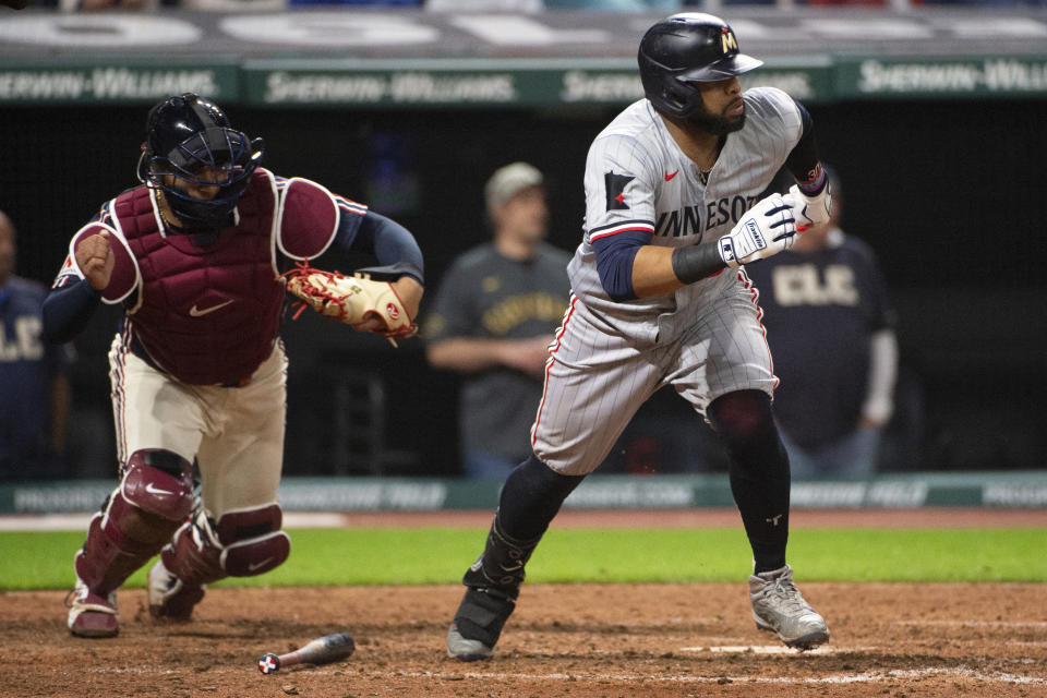 Minnesota Twins' Carlos Santana, right, hits a groundout for the final out as Cleveland Guardians' Bo Naylor, left, runs behind during the ninth inning of a baseball game in Cleveland, Friday, May 17, 2024. (AP Photo/Phil Long)