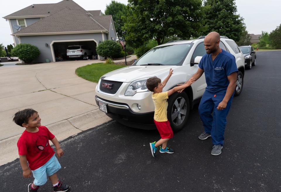 Jude Jasti, 5, runs to his father, Jamie, after work while Ari, 5, looks on at their home in Menomonee Falls.