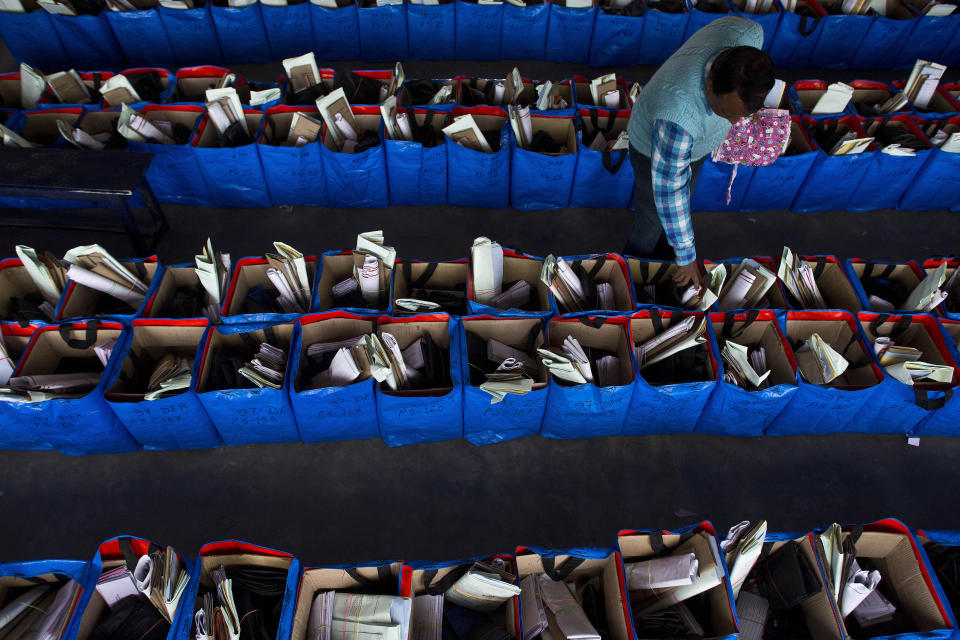 FILE - In this Monday, April 8, 2019 file photo, an election officer arranges election material at a distribution center ahead of general elections in Jorhat, Assam, India. The final phase of India’s marathon general election will be held on Sunday, May 19. The first of the election’s seven staggered phases was held on April 11. Vote counting is scheduled to start on May 23. India has 900 million eligible voters. (AP Photo/Anupam Nath, File)