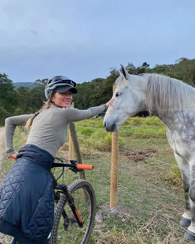 <p>Gisele Bundchen/Instagram</p> Gisele Bündchen stops to pet a horse during a bike ride.