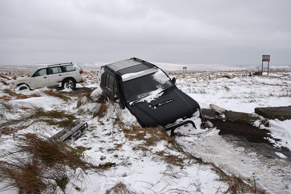 Abandoned vehicles are pictured in snow-covered moorland beside the A672, near to the M62 motorway. (Getty)