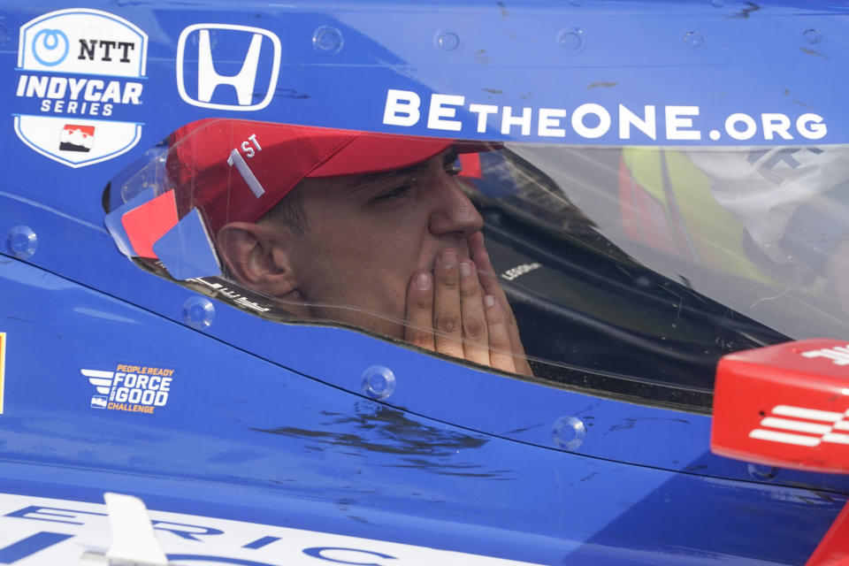 Alex Palou, of Spain, wipes his face after winning the IndyCar Grand Prix auto race at Indianapolis Motor Speedway, Saturday, May 13, 2023, in Indianapolis. (AP Photo/Darron Cummings)