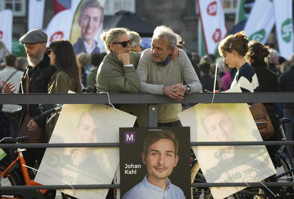 People pass by election campaign posters in Copenhagen, Denmark, Sunday, Oct. 30, 2022, ahead of the general election scheduled for Nov. 1, 2022. Denmark's election on Tuesday is expected to change its political landscape, with new parties hoping to enter parliament and others seeing their support dwindle. A former prime minister who left his party to create a new one this year could end up as a kingmaker, with his votes being needed to form a new government. (AP Photo/Sergei Grits)