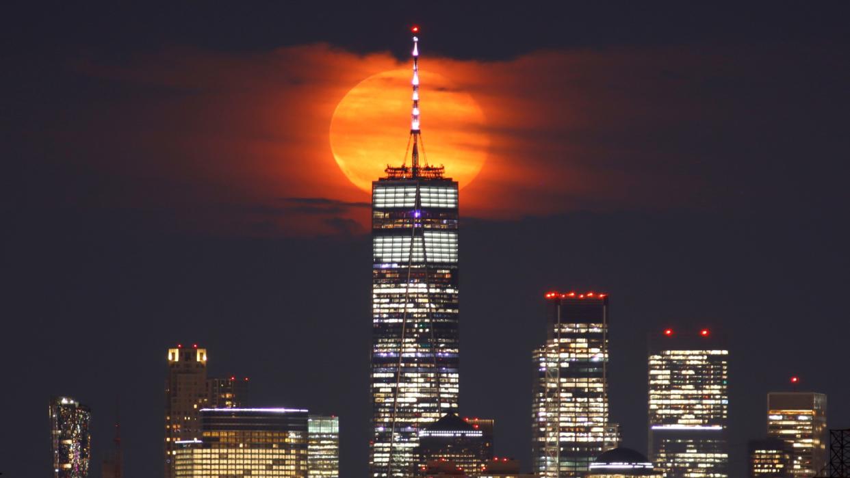  a full moon behind a skyscraper 