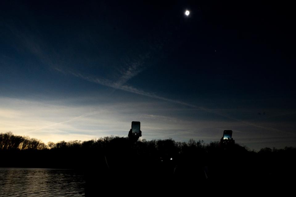 People film during the total solar eclipse at Miami Whitewater Forest in Miami Township on Monday.