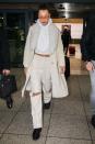 <p>In a cream corduroy coat with a fur collar, cropped hoodie, white ripped jeans by Private Policy, black creepers, and orange sunglasses at the airport in Dubai.</p>