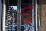 La frase "Racists Dine Here" ("Aquí comen racistas") en una puerta giratoria de un restaurante cerca de la Casa Blanca en Washington, el lunes 1 de junio de 2020, después de una serie de protestas por la muerte de George Floyd. Floyd murió después de ser inmovilizado por la policía de Minneapolis. (AP Foto/Carolyn Kaster)