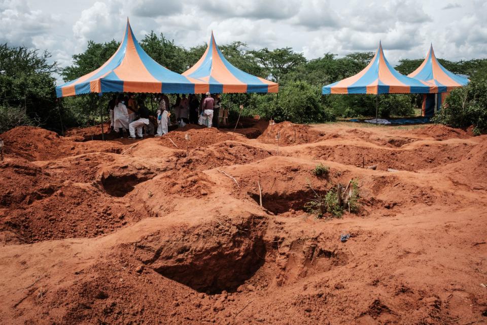 Workers take shelter while digging the ground to exume bodies from the mass-grave site in Shakahola, outside the coastal town of Malindi, on April 25, 2023.  / Credit: YASUYOSHI CHIBA/AFP via Getty Images