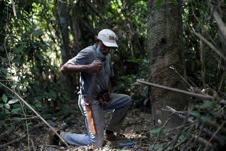 Raimundo Mendes de Barros, 71, who has worked as a rubber extractor for 57 years, prepares to cut a Seringueira rubber tree in Chico Mendes Extraction Reserve in Xapuri, Acre state, Brazil, June 22, 2016. REUTERS/Ricardo Moraes