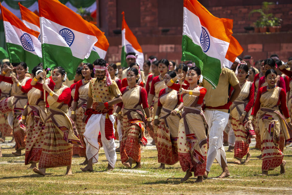 Assamese girls and boys in traditional attire carry Indian flags as they perform Bihu dance on Independence Day in Gauhati, northeastern state of Assam, India, Monday, Aug. 15, 2022. The country is marking the 75th anniversary of its independence from British rule. (AP Photo/Anupam Nath)