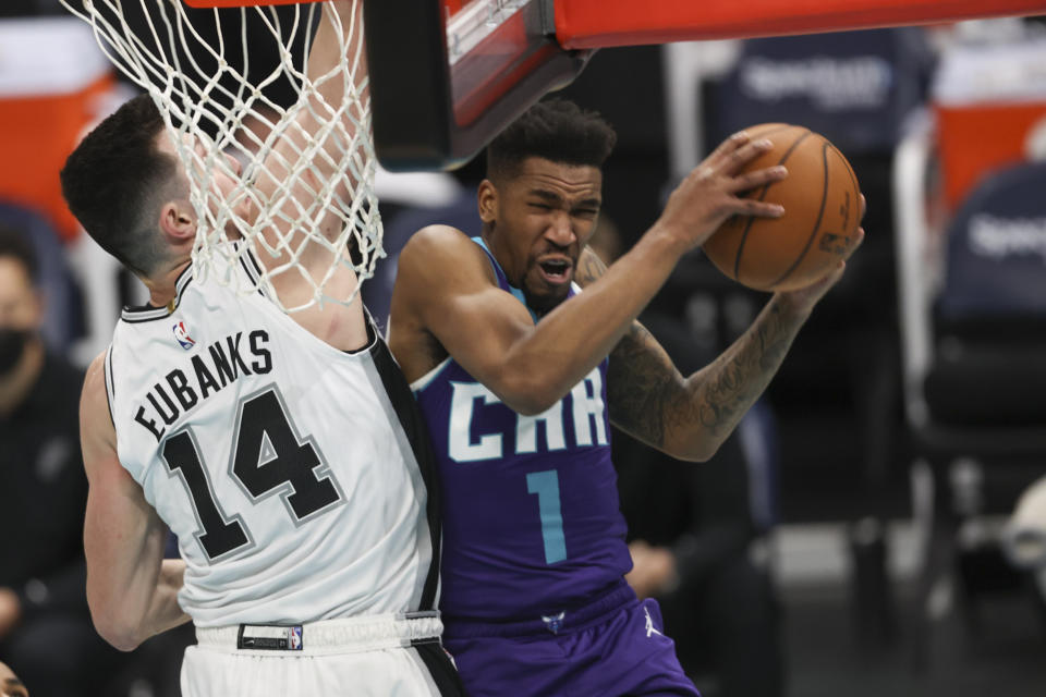 Charlotte Hornets guard Malik Monk (1) drives into San Antonio Spurs forward Drew Eubanks (14) during the first half of an NBA basketball game in Charlotte, N.C., Sunday, Feb. 14, 2021. (AP Photo/Nell Redmond)