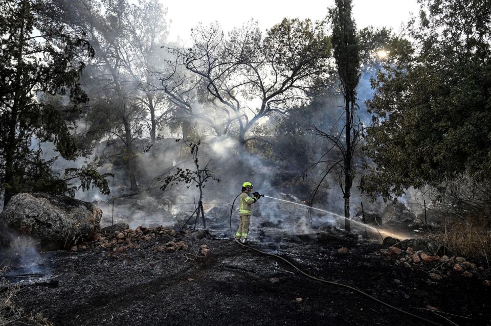 A firefighter works near Israel's border with Lebanon after Hezbollah said it launched more than 200 rockets and a swarm of drones at Israeli military sites on July 4 2024.