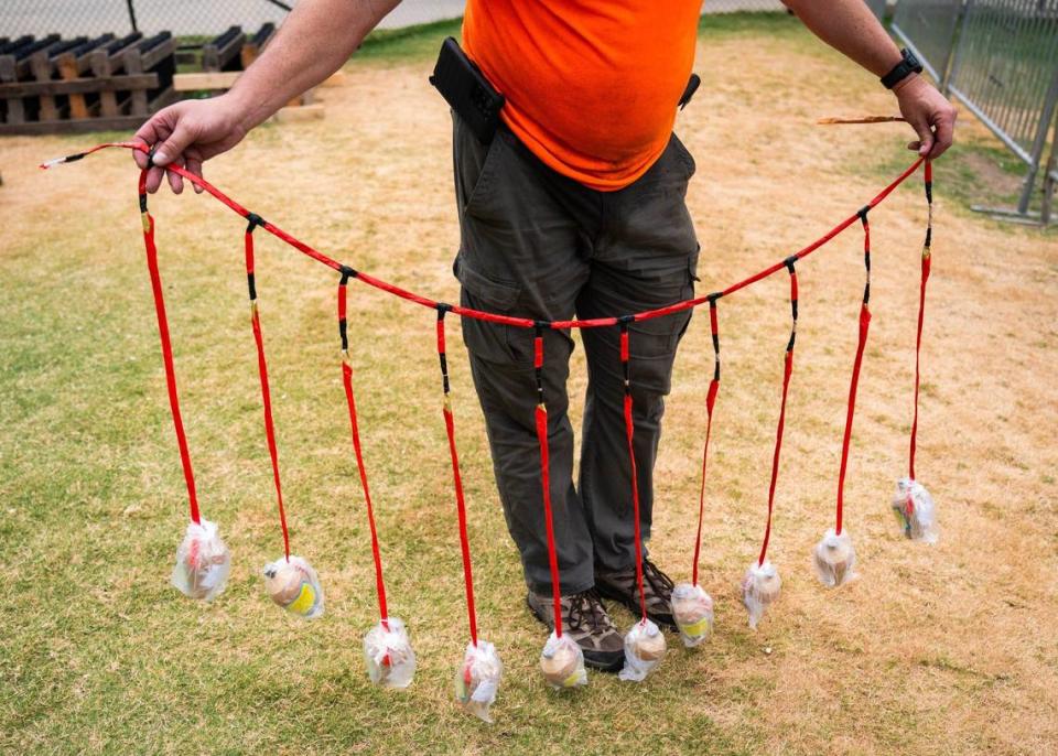 Russell Ellis holding a few of the many shells that will be shot off at Truist Field.