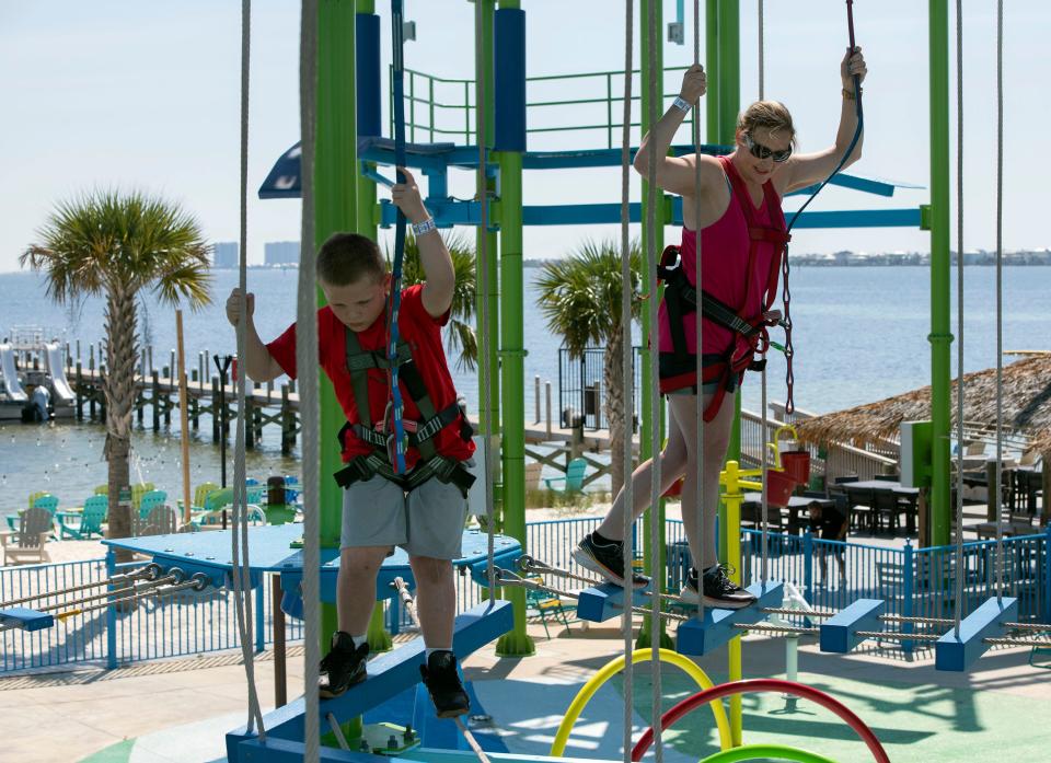 Kyler Johnson, 8, and his mom, Amanda Gordon, play on the zipline at Laguna's Adventure Park at Pensacola Beach on Wednesday.