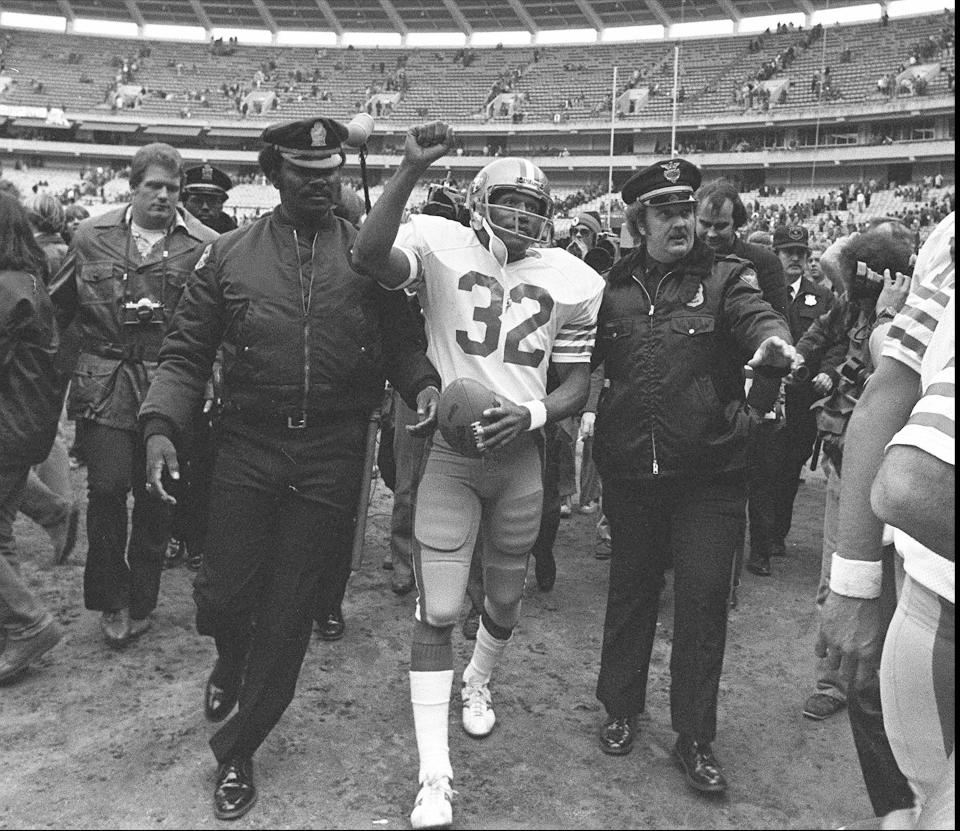 FILE - San Francisco 49ers running back O.J. Simpson is escorted from the field by police after the final NFL football game of his career, Dec. 16, 1979, against in the Atlanta Falcons at Atlanta Fulton County Stadium in Atlanta, Ga. Simpson, the decorated football superstar and Hollywood actor who was acquitted of charges he killed his former wife and her friend but later found liable in a separate civil trial, has died. He was 76. (AP Photo, File)