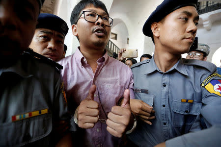 Detained Reuters journalist Wa Lone is escorted by police before a court hearing in Yangon, Myanmar May 16, 2018. REUTERS/Ann Wang