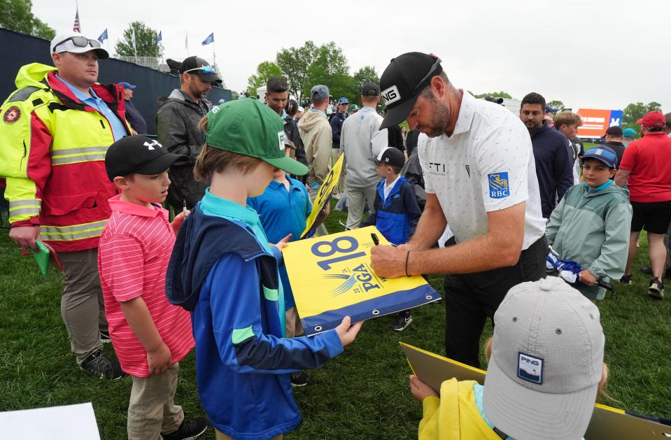 Corey Conners, right, signed autographs for fans during a weather delay in the PGA Championship practice round at the Valhalla Golf Course in Louisville, Ky. on May. 14, 2024.