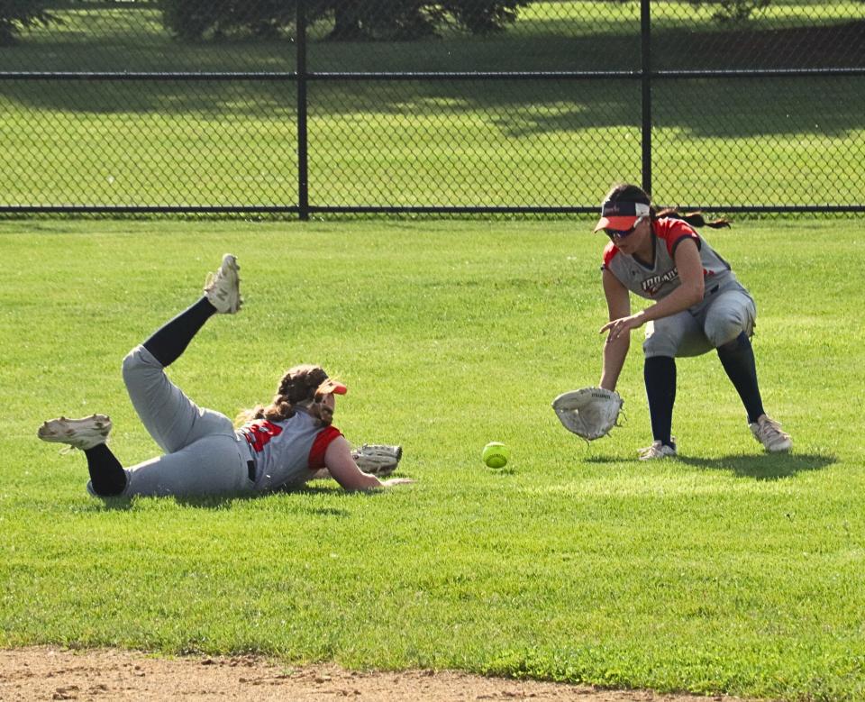 Pontiac second baseman Kendall Pitchford hits the ground after making a diving effort to catch a pop fly during Friday's game at Normal West. Centerfielder Maddie Gourley fields the ball. PTHS won the game 4-3.