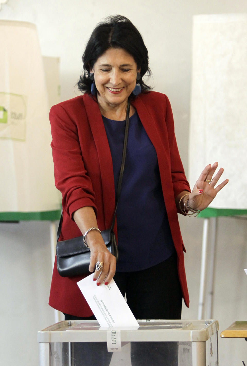 Salome Zurabishvili, former Georgian Foreign minister and presidential candidate from the European Georgia Party, casts her ballot at the polling station in Tbilisi, Georgia, Sunday, Oct. 28, 2018 . Voters in Georgia are choosing a new president for the former Soviet republic, the last time the president will be elected by direct ballot. (AP Photo/Shakh Aivazov)