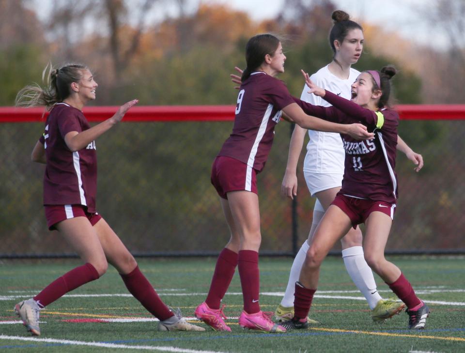 Aquinas's Sienna Fallone (9) celebrates her first half goal with teammates Bella Muratore (11) and Lily Bell.