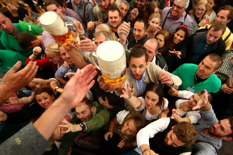 <p>Visitors reach for the first mugs of beer during the opening day of the 184th Oktoberfest in Munich. (Reuters/Michael Dalder) </p>