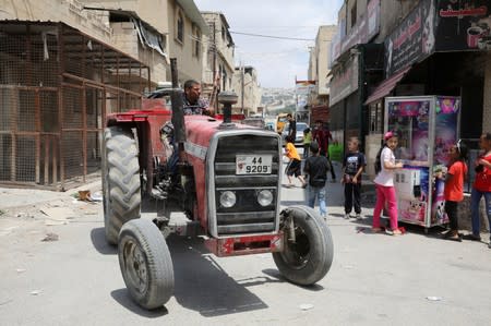 A Palestinian refugee drives his tractor in the street in Al-Baqaa Palestinian refugee camp, near Amman