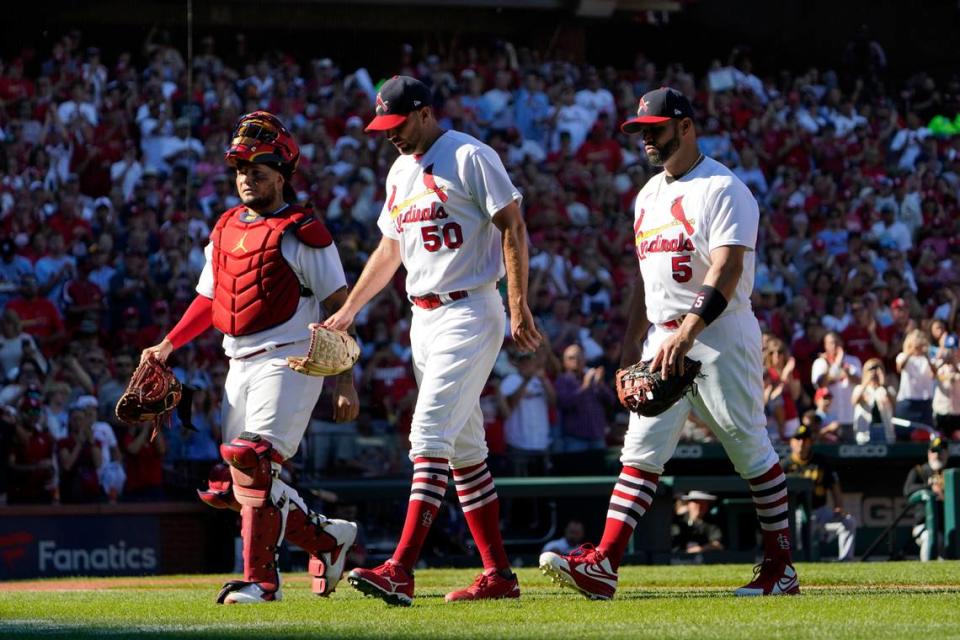 St. Louis Cardinals catcher Yadier Molina, left, starting pitcher Adam Wainwright (50) and first baseman Albert Pujols (5) walk off the field together as they are all removed at the from the game against Pittsburgh at the same time in the fifth inning Sunday in St. Louis. Molina and Pujols are retiring after this season, while Wainwright’s future is still up in the air.