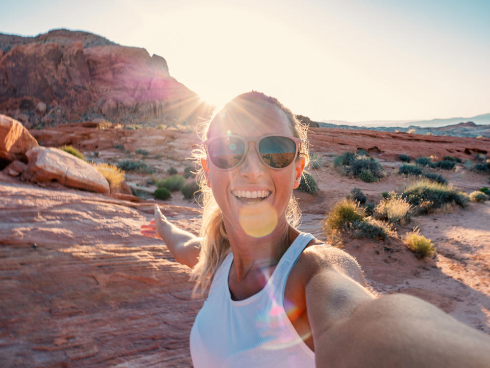 Woman takes photo in deserty surroundings