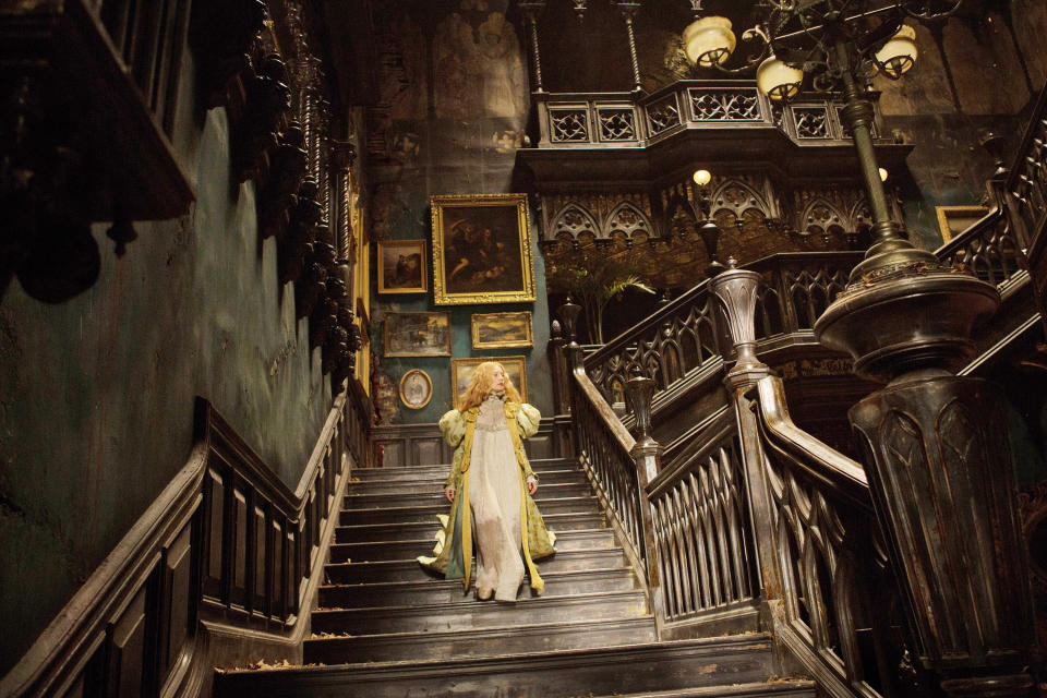 A woman walks down a grand staircase