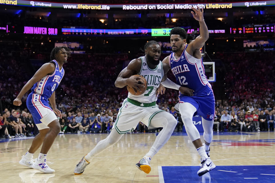 Boston Celtics' Jaylen Brown (7) drives to the basket between Philadelphia 76ers' Tobias Harris (12) and Tyrese Maxey during the first half of Game 6 of an NBA basketball playoffs Eastern Conference semifinal, Thursday, May 11, 2023, in Philadelphia. (AP Photo/Matt Slocum)