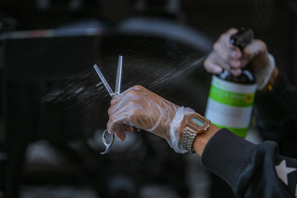 A hair salon worker demonstrates how to clean one's tools as per the standard operating procedures in Ampang June 7, 2020. — Picture by Hari Anggara