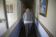 In this photo taken Thursday, Dec. 5, 2019, Rosalie Harris, 80, walks to her room at the Cedars Care Home in Calistoga, Calif. Even before widespread blackouts hit California this fall, the utility that triggered them showed signs it wasn’t fully prepared. An Associated Press review reveals persistent problems during four smaller shutoffs that Pacific Gas & Electric did starting last year so power lines downed by strong winds wouldn’t spark wildfires. (AP Photo/Eric Risberg)