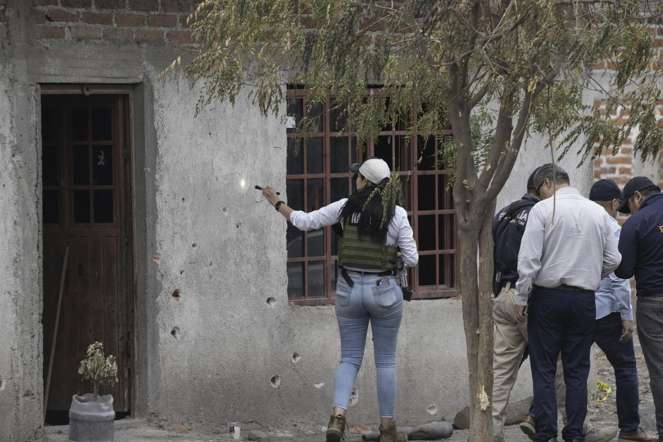 Municipal police investigate the crime scene where Hipolito Mora, the leader of an armed civilian movement that once drove a drug cartel out of the western Mexico state of Michoaca, was killed in his hometown of La Ruana, Mexico, Friday, June 30, 2023. (AP Photo/Eduardo Verdugo)