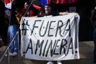A protester holds a banner with a hashtag that reads in Spanish: "Get out mining", as protesters learn that Panama's Supreme Court has declared unconstitutional a 20-year concession for a Canadian copper mine that had sparked weeks of protests, in Panama City, Tuesday, Nov. 28, 2023. (AP Photo/Arnulfo Franco)