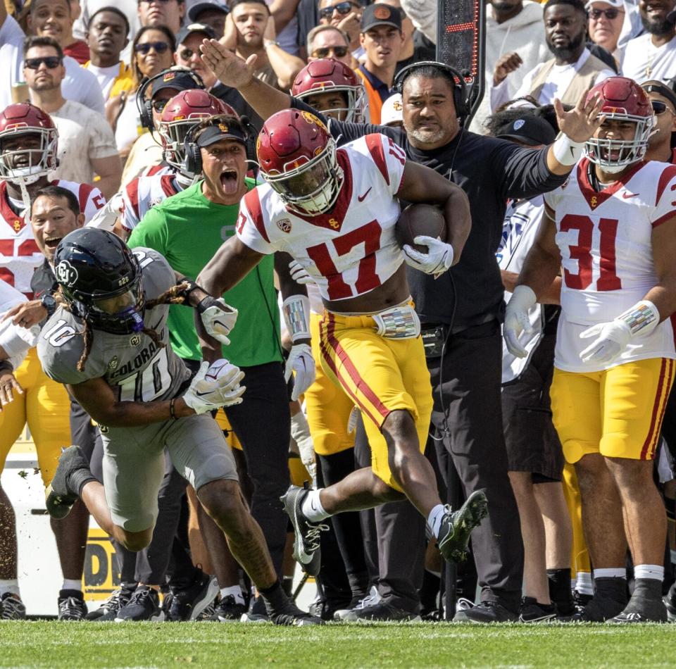 People on the sideline reacts as USC cornerback Christian Roland-Wallace Jensen returns an interception against Colorado