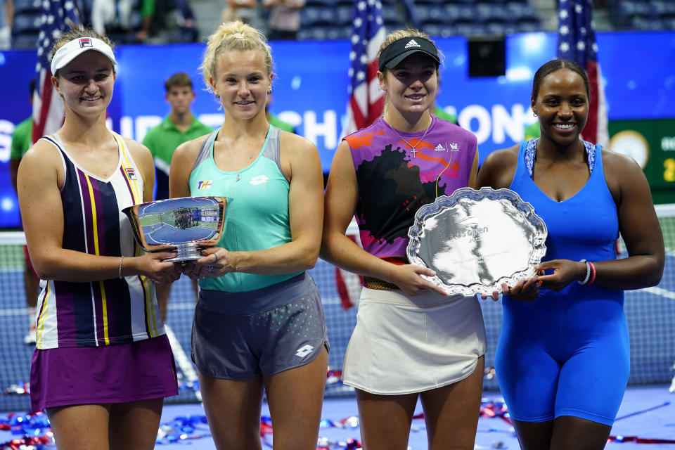 Barbora Krejcikova, of the Czech Republic, left, and Katerina Siniakova, of the Czech Republic pose for photos after defeating Taylor Townsend, of the United States, right, and Caty McNally, of the United States, in the final of the women's doubles at the U.S. Open tennis championships, Sunday, Sept. 11, 2022, in New York. (AP Photo/Matt Rourke)