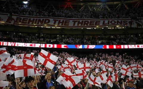 England's supporters wave flags during the playing of the national anthem ahead of the UEFA Euro 2020 Group A qualification football match between England and Czech Replublic at Wembley Stadium in London on March 22, 2019 - Credit: AFP