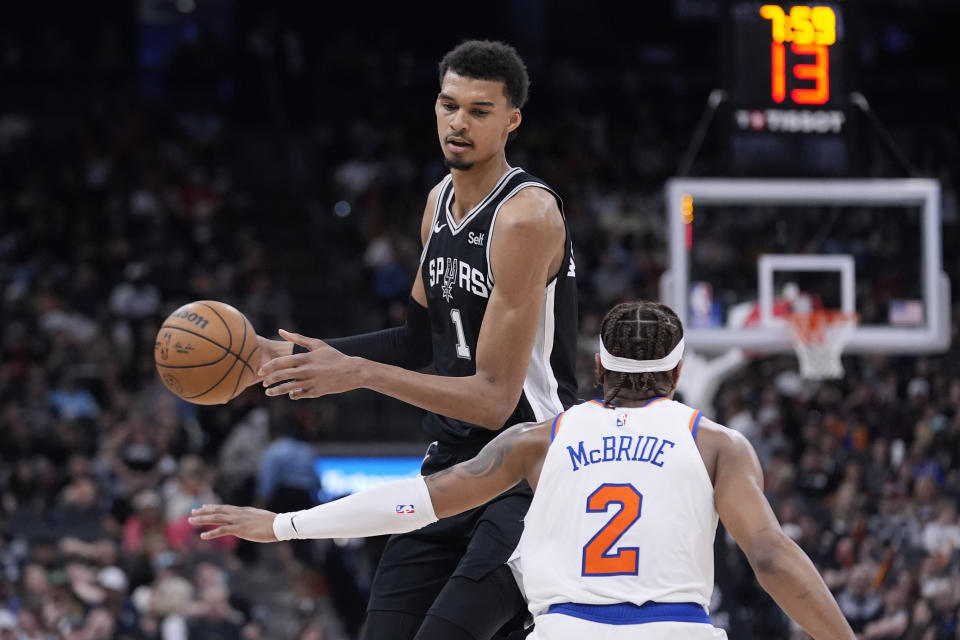 San Antonio Spurs center Victor Wembanyama (1) tries to move to ball past New York Knicks guard Miles McBride (2) during the second half of an NBA basketball game in San Antonio, Friday, March 29, 2024. (AP Photo/Eric Gay)