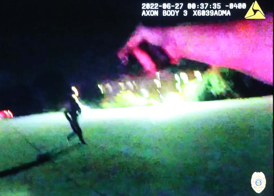 This still image from police body camera footage shows a police officer pointing a gun at Jayland Walker.