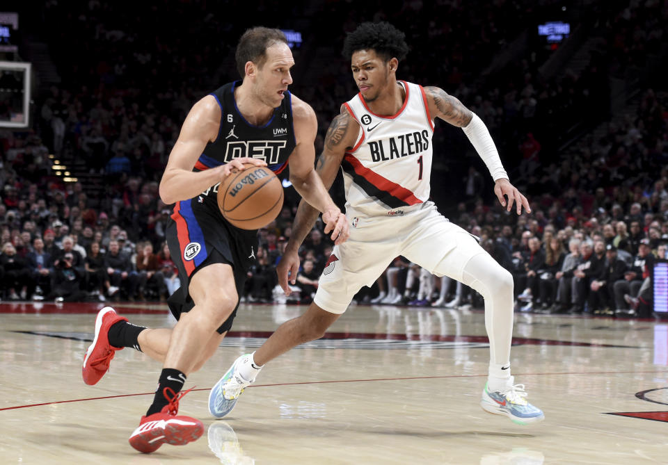 Detroit Pistons forward Bojan Bogdanovic, left, drives to the basket on Portland Trail Blazers guard Anfernee Simons during the second half of an NBA basketball game in Portland, Ore., Monday, Jan. 2, 2023. (AP Photo/Steve Dykes)