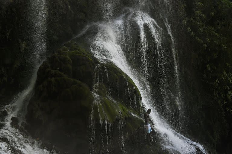 Un peregrino vudú se baña en una cascada que se cree que tiene poderes purificadores durante una celebración anual en Saut d 'Eau, Haití, el 16 de julio 

