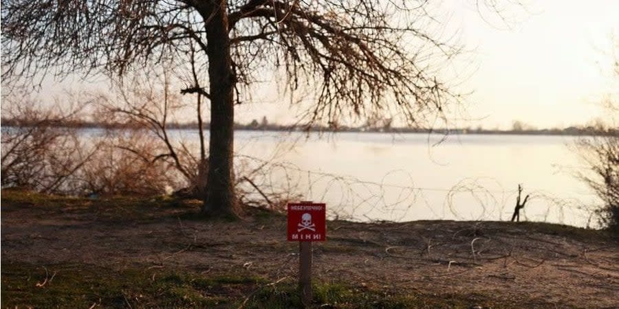 A mine danger sign in front of the Dnipro River in Kherson, January 2023