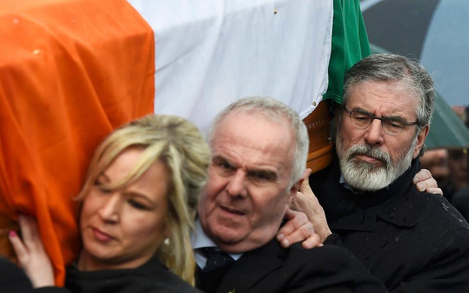 Sinn Feinn Leader Michelle O'Neill and Sinn Feinn President Gerry Adams carry the coffin of Martin McGuinness through the streets of Londonderry, Northern Ireland - Credit: CLODAGH KILCOYNE /REUTERS 