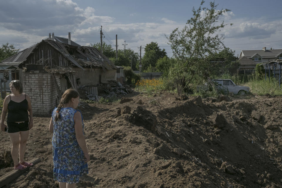 Gente que vive en las afueras de Sloviansk, en el este de Ucrania, comprueba el daño provocado por los ataques con misiles, el martes 19 de julio de 2022. (Mauricio Lima/The New York Times).