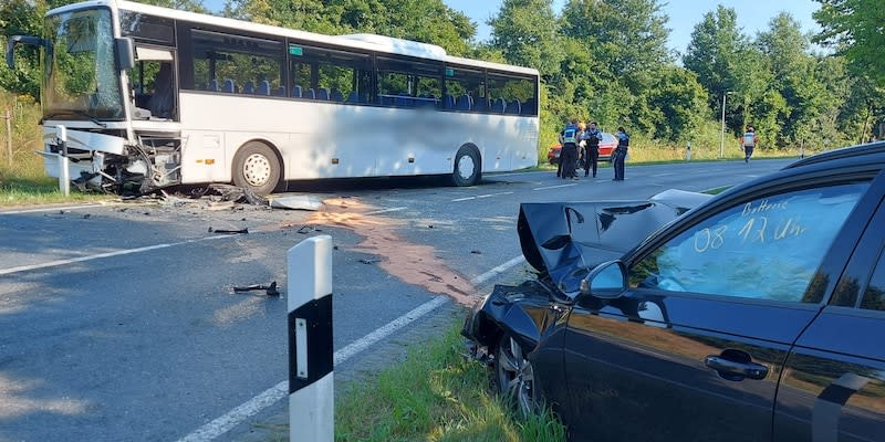 Ein beschädigter Schulbus und ein kaputtes Auto stehen an einer Unfallstelle in Dülmen.<span class="copyright">dpa</span>