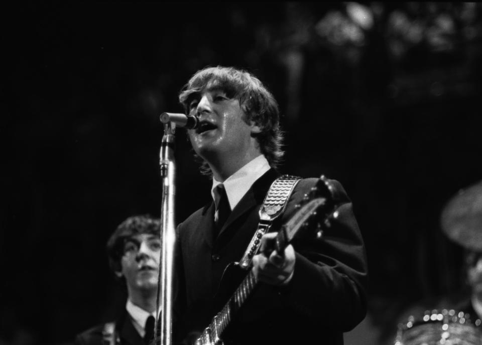 The Beatles' John Lennon sings while Paul McCartney looks on during the concert at Cincinnati Gardens in 1964.
