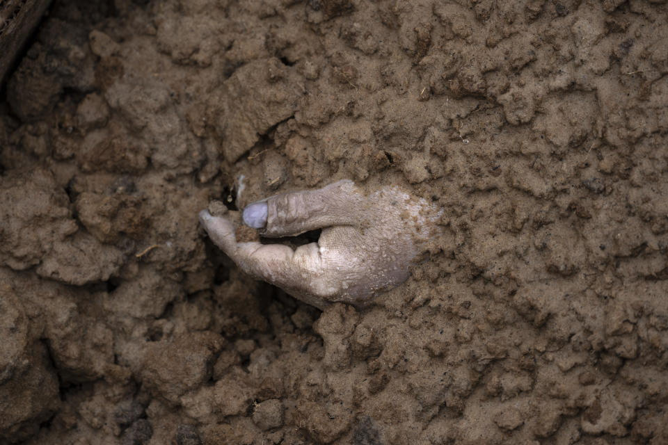 The hand of a corpse buried along with other bodies is seen in a mass grave in Bucha, in the outskirts of Kyiv, Ukraine, Sunday, April 3, 2022. This was the year war returned to Europe, and few facets of life were left untouched. Russia’s invasion of its neighbor Ukraine unleashed misery on millions of Ukrainians, shattered Europe’s sense of security, ripped up the geopolitical map and rocked the global economy. The shockwaves made life more expensive in homes across Europe, worsened a global migrant crisis and complicated the world’s response to climate change. (AP Photo/Rodrigo Abd)