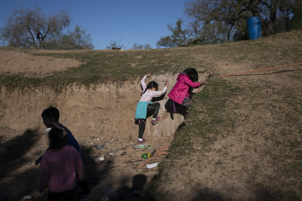 Children play on the exposed shores of the Parana River, in a fishing village on Espinillo Island, on the other side of the river from Rosario, Argentina, Thursday, July 29, 2021. Argentina´s National Water Institute has defined the river´s falling water levels as the worst since 1994, saying that in September, the water levels in several provinces will reach their lowest ever. (AP Photo/Victor Caivano)