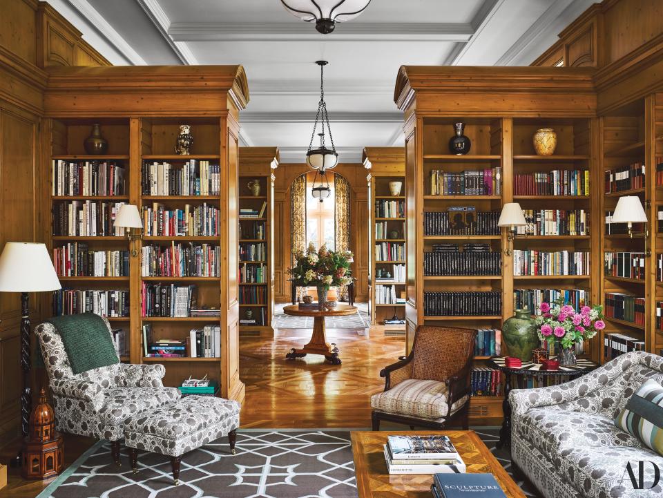 In the pine-paneled library, a Penny Morrison linen covers the Jonas armchair, ottoman, and sofa. English mahogany caned chair with cushion of a striped cotton by Jed Johnson Home.