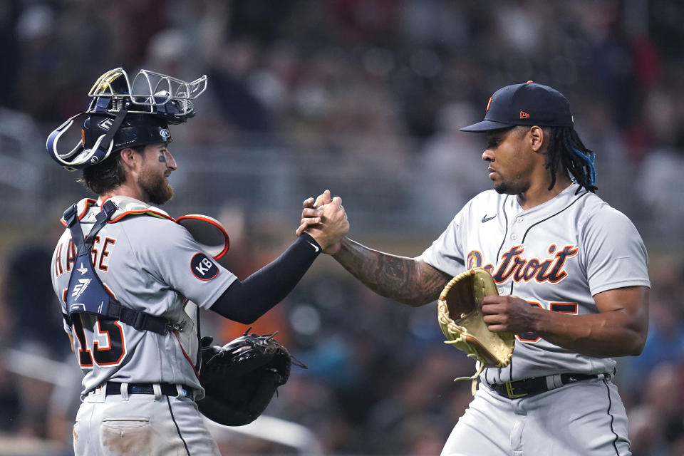 Detroit Tigers catcher Eric Haase, left, and relief pitcher Gregory Soto clasp hands following the team's 5-3 win in a baseball game against the Minnesota Twins on Tuesday, Aug. 2, 2022, in Minneapolis. (AP Photo/Abbie Parr)